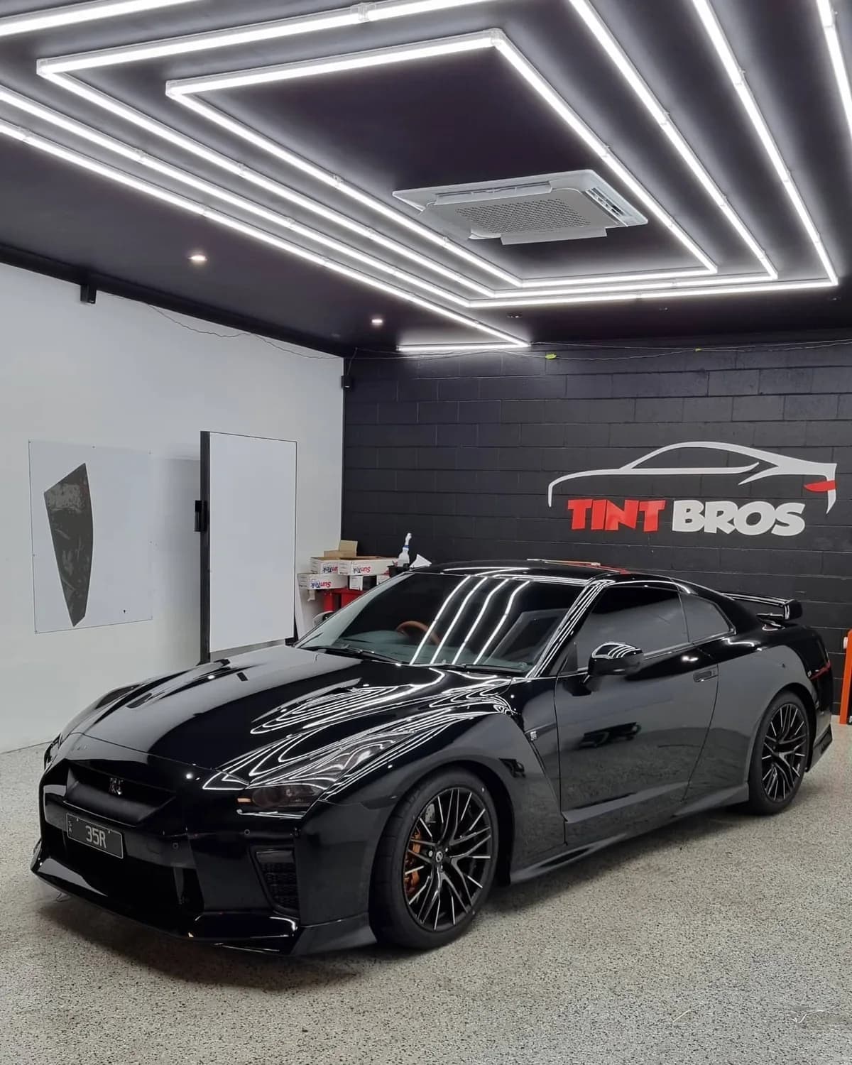 A Nissan GT-R with dark window tint and blacked-out lights