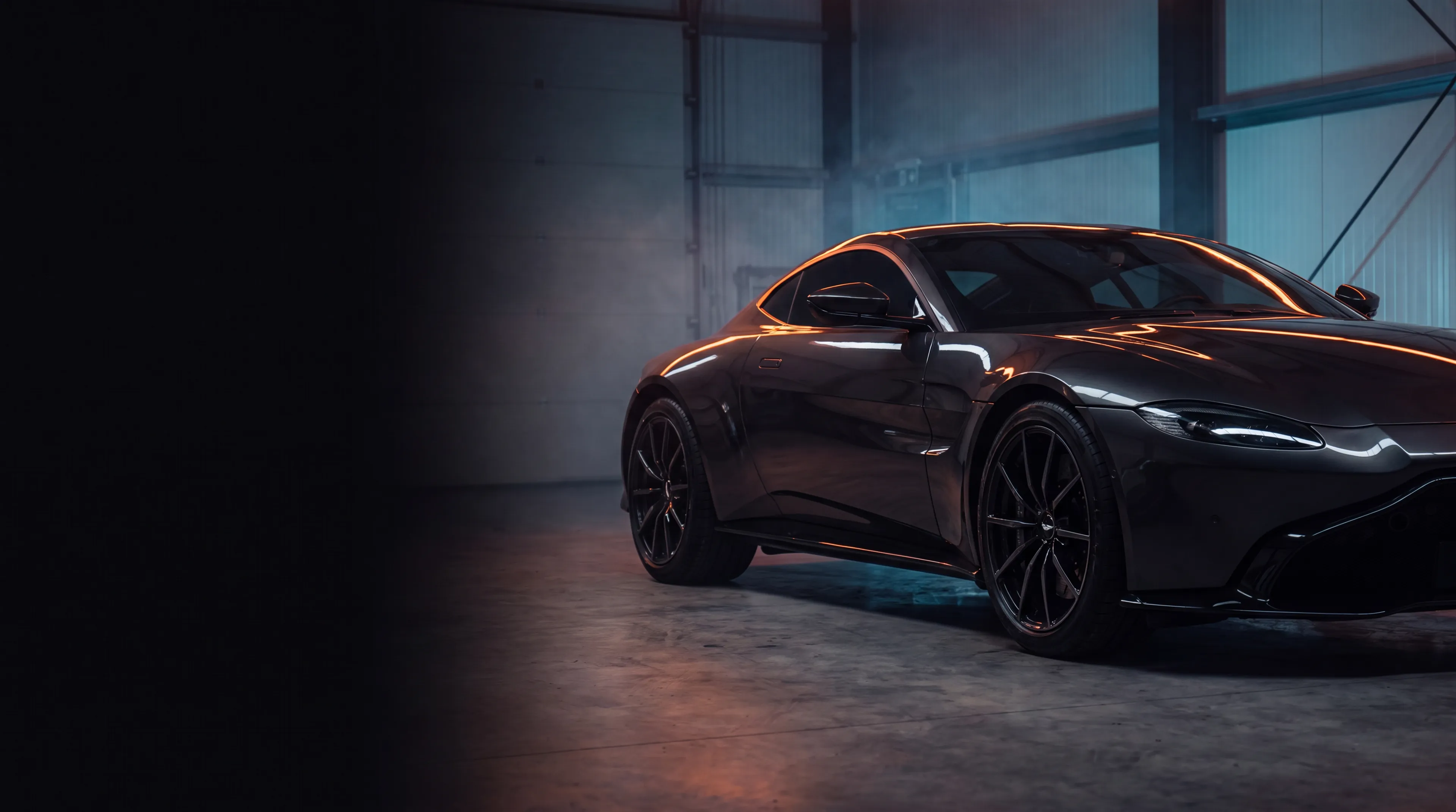 Dark sports car under studio lighting, a backdrop for this Adelaide window tint comparison guide.